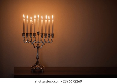Hanukkah menorah, or hanukkiah in the light of the sun at sunset for Jewish holiday Hanukkah. Hanukkah lamp, nine-branched candelabrum with burning candles.