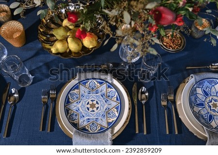 A Hanukkah Table Setting of Timeless Elegance in Blue and White Photographed from Above.