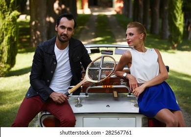 Happily Married Couple Enjoying A Beautiful Day Outdoors While Leaning On Their Convertible Antique Car, Handsome Wealthy Man And His Gorgeous Female Posing Outdoors, People Spending Time Together 