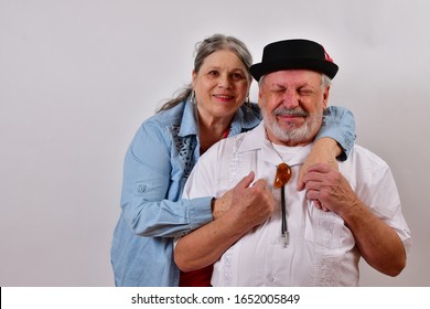 Happily Married Couple Facing Camera.
Deliriously Happy Old Man With His Wife Of 40 Years  Hugging And Smiling.