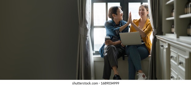 happiness asian couple male and female friend enjoy chat gossip together in coffee break asian froend use laptop smartphone casual meeting next to window home background