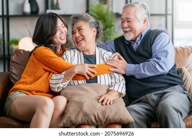 happiness asian family candid of daughter hug grandparent mother farther senior elder cozy relax on sofa couch surprise visiting in living room at home,together hug cheerful asian family at home