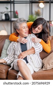 Happiness Asian Family Candid Of Daughter Hug Grandparent Mother Senior Elder Mom Cozy Relax On Sofa Couch In Living Room,Beautiful Family Of Mother And Daughter Together, Hugging And Kissing At Home