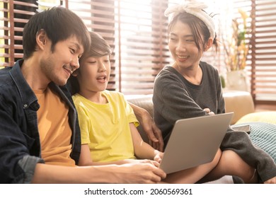 Happiness Asian Family Sunday Morning Mom Dad Son Sitting Together Using Laptop Play Game Online Together With Exited Fun Cheerful Casual Relax Relation In Living Room Home Interior Background