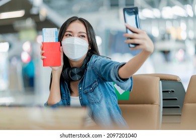 happiness asian female take selfie phot with passport and flight ticket ready to go travel,asian female casual cloth using smartphone take photo at waiting area in airport terminal travel concept
