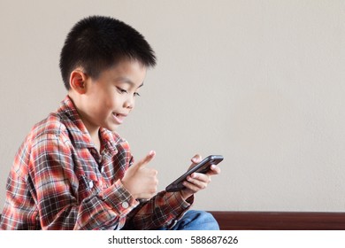 Happiness Asian Kid Playing On Smart Phone