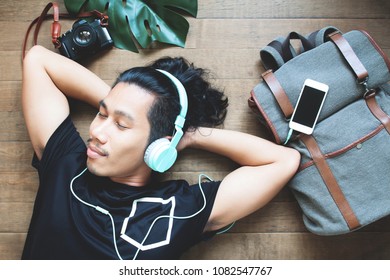 Happiness Asian Man Listening To Music Lying Down On The Floor, Travel And Vacation Concept