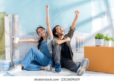 happiness asian marry couple cheerful celebrate hand rise together while encourage support cheering up for re painting new living room home renovation and relocation ,relax couple sit on floor joyful - Powered by Shutterstock