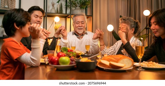 happiness asian multi generation dining together,family holding hands and praying on thanksgiving before holiday dinner,grandparent grandchildren stay together in thanksgiving traditional dinner home - Powered by Shutterstock