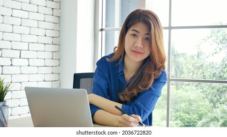 Happiness Asian Woman Working From Home Using Laptop Online Meeting In Home Office. Happy Relax Time Asian Business Woman Typing Keyboard Use Notebook Laptop Smiling, Laughing, Yawn At Home Office.