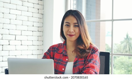 Happiness Asian Woman Working From Home Using Laptop Online Meeting In Home Office. Happy Relax Time Asian Business Woman Typing Keyboard Use Notebook Laptop Smiling, Laughing, Yawn At Home Office.