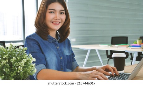 Happiness Asian Woman Working From Home Using Laptop Online Meeting In Home Office. Happy Relax Time Asian Business Woman Typing Keyboard Use Notebook Laptop Smiling, Laughing, Yawn At Home Office.