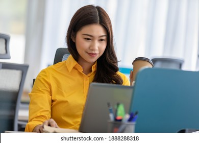 Happiness Attractive Asian Woman In Yellow Shirt Working With Computer Laptop Thinking To Get Ideas And Requirement In Business Startup At Modern Office Or Co-working Space,Business Startup Concept