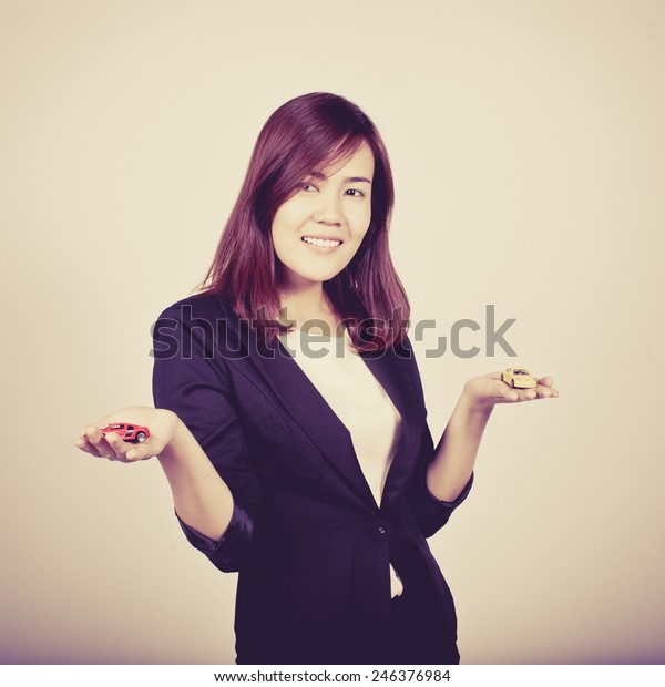 Happiness beautiful business woman with a toy car\
in her hand, process\
color