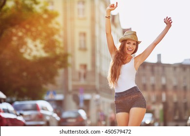 Happiness concept - happy woman having fun on city street during summer