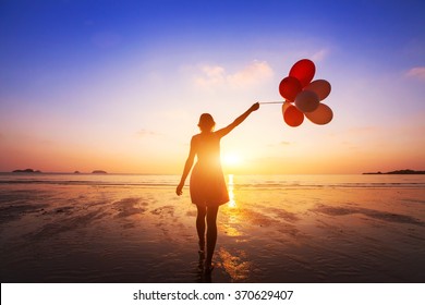 happiness concept, positive emotions, happy girl with multicolored balloons enjoying summer beach at sunset 