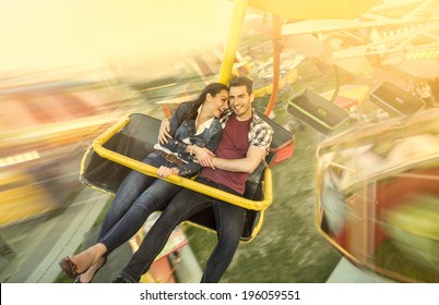 Happiness Couple Riding On Ferris Wheel At Amusement Park