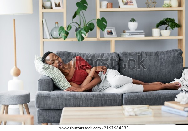 Happiness is created with one\
nap at a time. Shot of a young woman having a nap on the sofa at\
home.