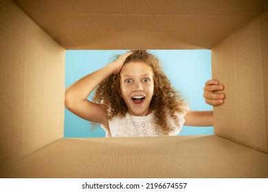 Happiness, Delight. Emotional Kid, Little Girl Looking Inside Box During Opening, Unpacking It. Delivery, Surprise, Gift, Wow Emotions Concept. Black Friday, Holidays And Online Shopping