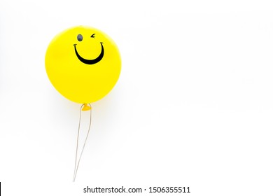 Happiness Emotion. Yellow Balloon With Smile On White Background Top View Copy Space