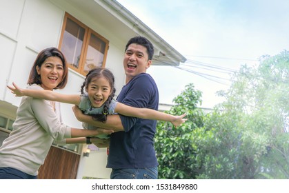 Happiness Family Play Together At Yard Outside Home. The Parents Smile With Their Daughters