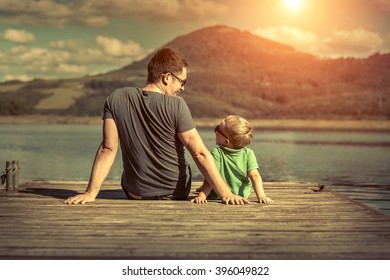 Happiness father and son on the pier at sunny day under sunlight. - Powered by Shutterstock