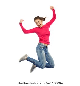 happiness, freedom, power, motion and people concept - smiling young woman jumping in air with raised fists over white background