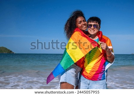 Happiness Lesbian LGBTQ couple holiday summer on the beach with show  rainbow flag a symbol of the LGBT community freedom Equality love concept.