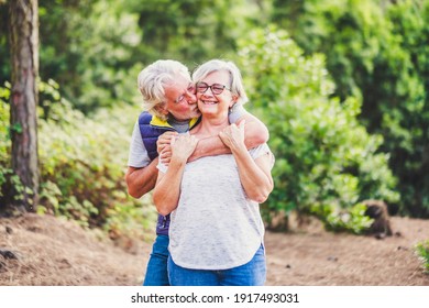 Happiness And Love Relationship. Couple Of Old People Man And Woman Senior Hug And Kiss In Outdoor Park - Elderly Retired Lifestyle And Joyful - Concept Of Together Forever And Outdoor Leisure