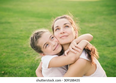 Happiness - Mother Hugging Her Child During The Walk In The Park Looking Up. 