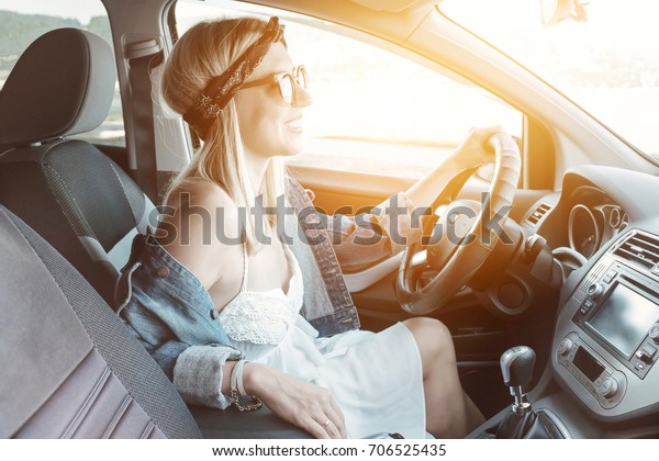 Happiness woman\
driving black car at sunny\
day