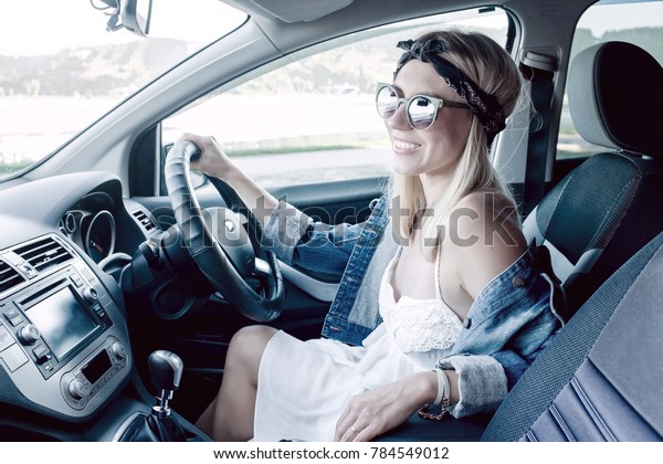 Happiness woman\
driving black car at sunny\
day