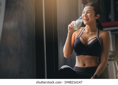 Happiness Woman In Sportswear Drinking Protein Powder Milkshake After Workout At Fitness Gym.