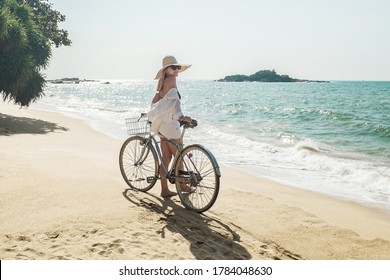 Happiness woman traveler with her bicycle rides on sea coastline and looking on beautifull seascape view in sunny summer day on beach. Freedom, Travell, Journej,  concept. - Powered by Shutterstock