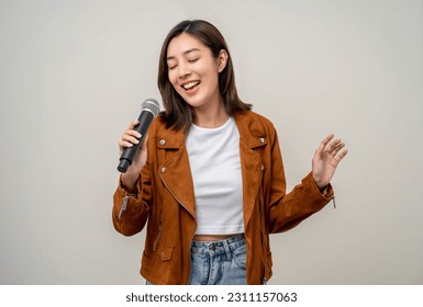 Happiness young asian woman singing song. Artist vocalist singer on isolated background. Confident woman public speaking talking with microphone in studio. - Powered by Shutterstock