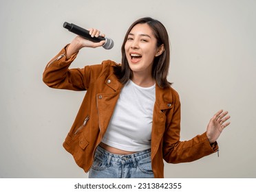 Happiness young asian woman singing song. Artist vocalist singer on isolated background. Confident woman public speaking talking with microphone in studio. - Powered by Shutterstock