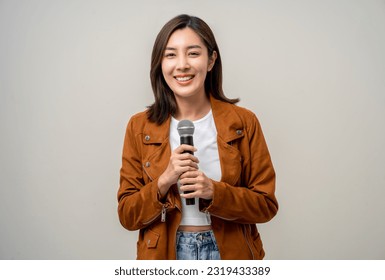 Happiness young asian woman singing song. Artist vocalist singer on isolated background. Confident woman public speaking talking with microphone in studio.