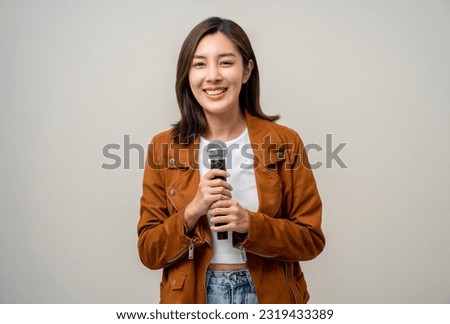 Happiness young asian woman singing song. Artist vocalist singer on isolated background. Confident woman public speaking talking with microphone in studio.