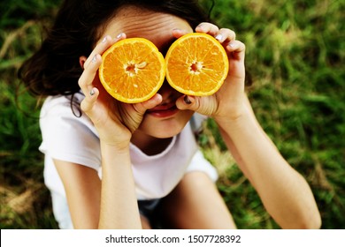 Happy 12 Year Old Girl Smiling And Holding Orange Slices