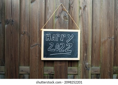 Happy 2022 weitten on a chalkboard in the garden                      