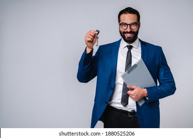 Happy 25s Arab businessman holding clipboard and car keys isolated over grey background - Powered by Shutterstock