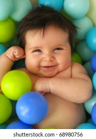  A happy 3 months old baby in a bath of balls.
