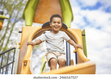 A Happy 3 years old boy on a swing. Happy kid on playground - Powered by Shutterstock