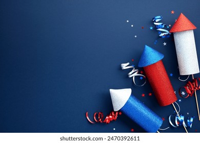 Happy 4th of July flat lay composition with firework rockets and confetti on dark blue background. - Powered by Shutterstock