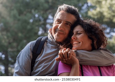 Happy 50s couple embracing during hiking adventure, authentic mature relationship outdoors - Powered by Shutterstock