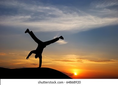 Happy acrobat man at the sunset.Emotional scene.