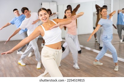 Happy active energetic multiracial dancers of different ages dancing aerobics at lesson in modern class studio - Powered by Shutterstock