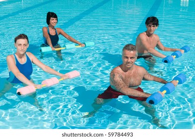 Happy active fitness people doing exercise with aqua dumbbell in a swimming pool
