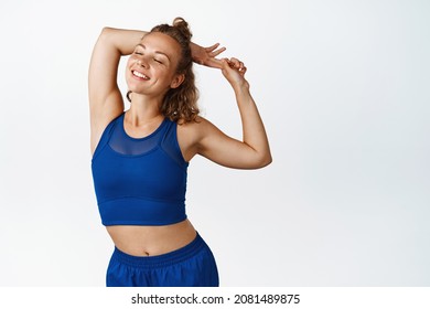 Happy active fitness woman stretching and warming up before exercises, smiling pleased after jogging. Energetic funner looking motivated, white background - Powered by Shutterstock