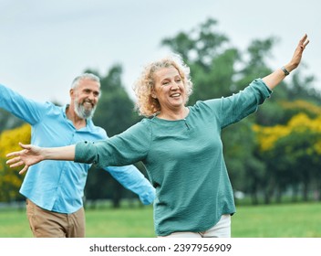 Happy active mid aged adult couple having fun walking and balancing and bonding in park or nature outdoors, healhty active mature people exercise concept - Powered by Shutterstock